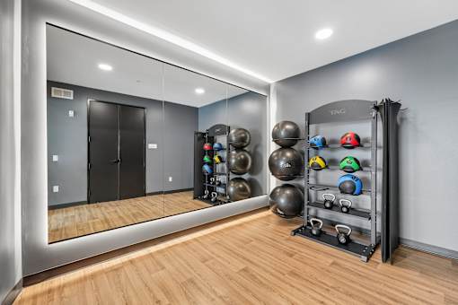 A gym with a mirror, weights, and a rack.