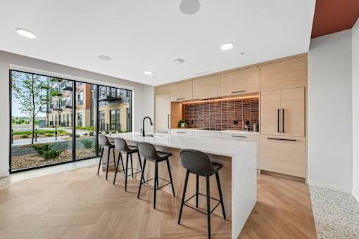 A modern kitchen with a bar area and a view of the outdoors.