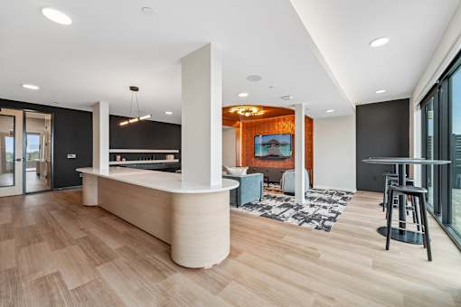 A modern interior with a reception desk and a bar area.