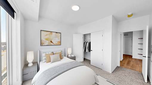 A bedroom with a large bed and a painting on the wall.