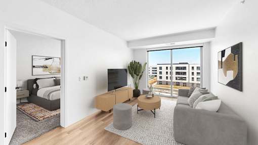 A modern living room with a grey sofa, a wooden coffee table, and a large window overlooking a cityscape.