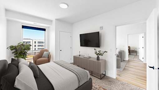 A modern bedroom with a large bed and a flat-screen TV mounted on the wall.