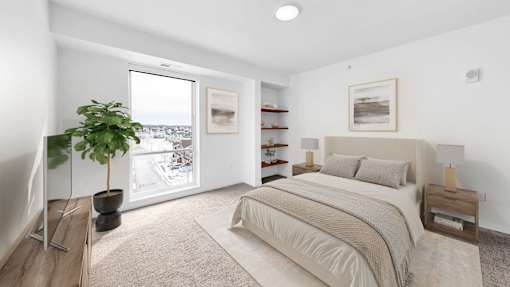 A bedroom with a large bed and a potted plant.