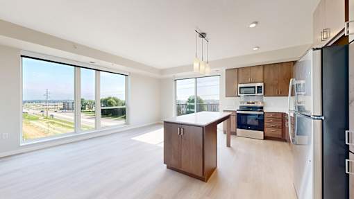 A kitchen with a refrigerator, microwave, and oven.