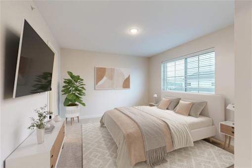 A bedroom with a large bed and a flat screen TV mounted on the wall.