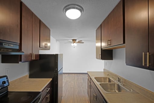 a kitchen with dark cabinets and a ceiling fan