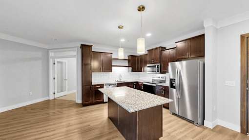 A modern kitchen with wooden cabinets and stainless steel appliances.