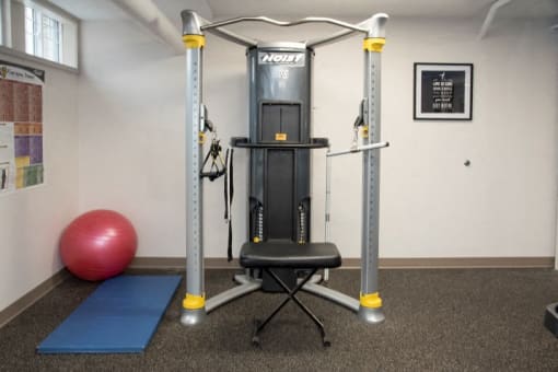 a gym bench with a fitness ball and mat in the corner of a room