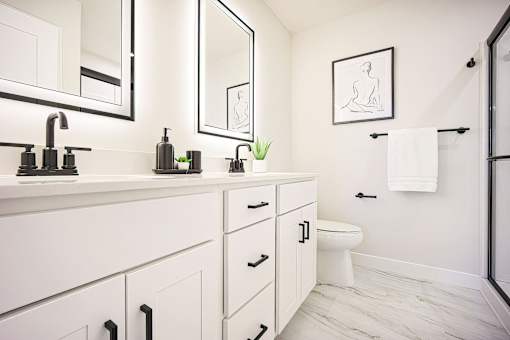 A bathroom with a white counter top and a white toilet.