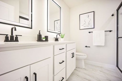 a bathroom with white cabinets and a toilet and a sink