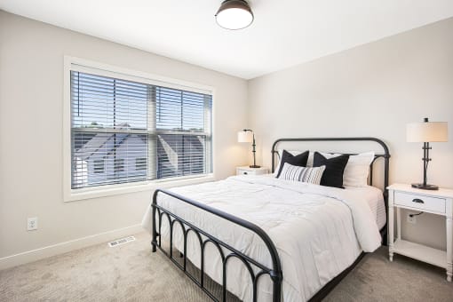 an empty bedroom with a bed and a window