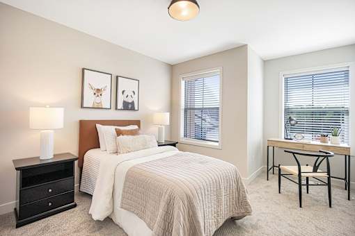 A bedroom with a bed, nightstand, and chair.