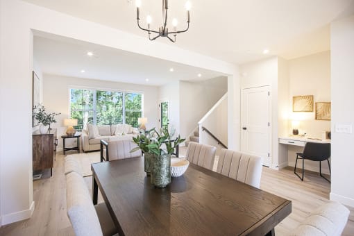 a living room and dining room with a wooden table and chairs