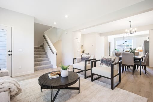 a living room with a table and chairs and a staircase