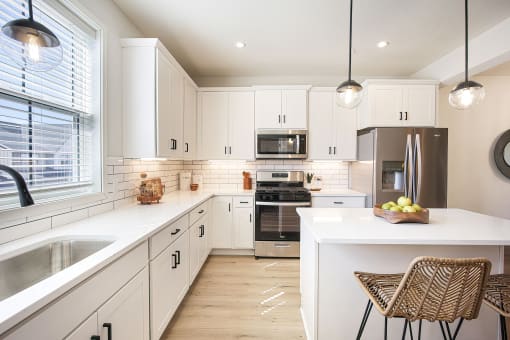 a white kitchen with stainless steel appliances and white cabinets
