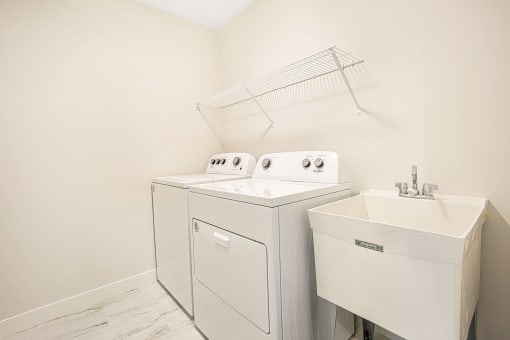 a washer and dryer in a room with a sink and a washing machine