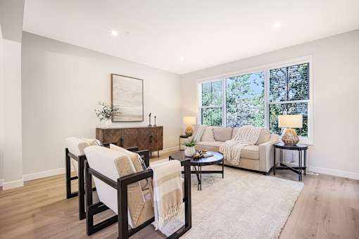 A living room with a couch, chairs, and a coffee table.