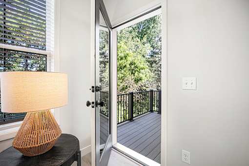 A table with a lamp on it in front of a window.