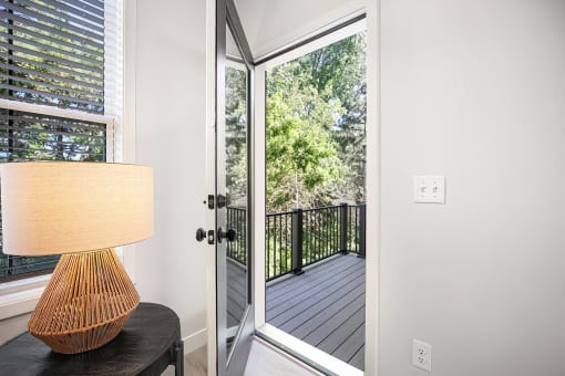 a room with a lamp and a door to a balcony