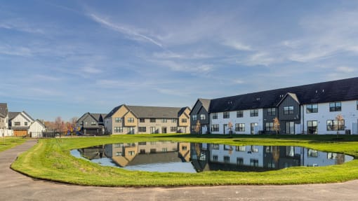 a pond in front of a row of houses