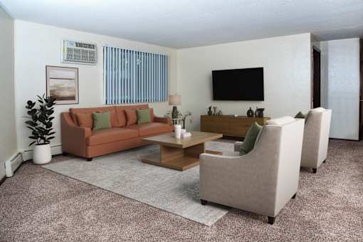A living room with a couch, chairs, and a television.