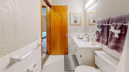 A bathroom with a white toilet, sink, and a white bathtub.