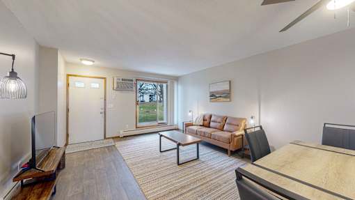 A living room with a couch, a coffee table, and a television.