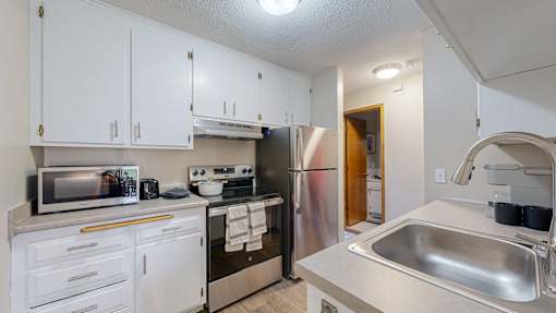 A kitchen with white cabinets and stainless steel appliances.