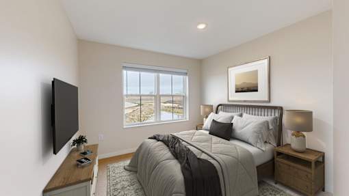 A bedroom with a large bed, a flat screen TV, and a window overlooking a balcony.