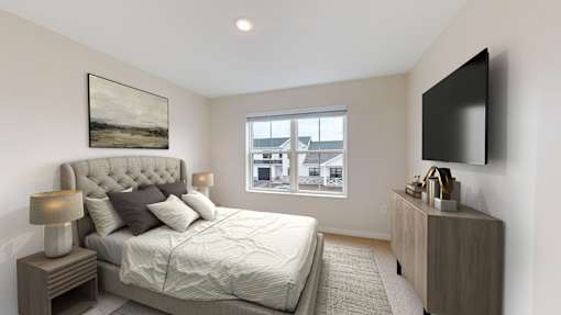 A bedroom with a large bed and a flat screen TV mounted on the wall.