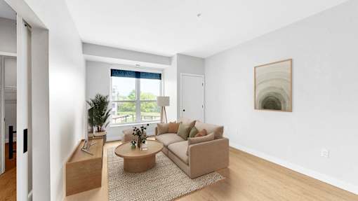 A living room with a couch, a coffee table, and a painting on the wall.
