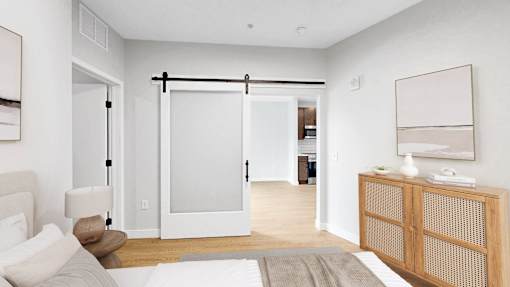 A bedroom with a bed, nightstand, and sliding door.