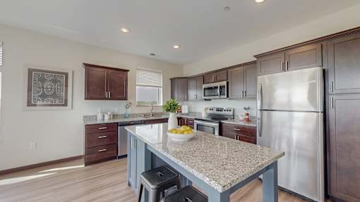 A kitchen with a granite countertop and stainless steel appliances. at Lake Jonathan Flats, Chaska, MN