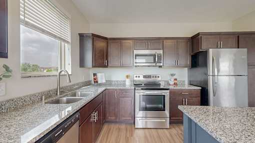 A kitchen with brown cabinets and stainless steel appliances. at Lake Jonathan Flats, Minnesota