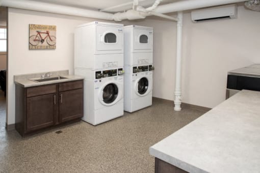 a laundry room with two washers and a sink