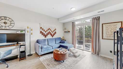 A living room with a blue couch and a wooden coffee table.