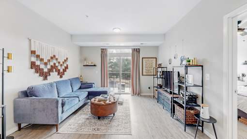 A living room with a grey couch and a wooden coffee table.