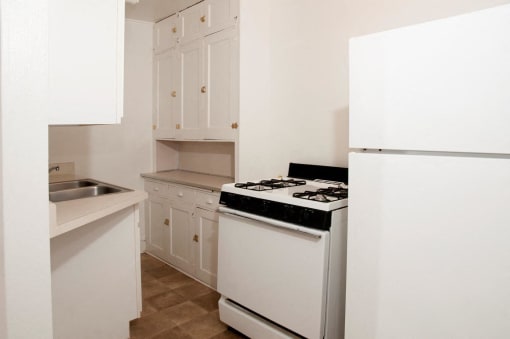 a kitchen with white cabinets and a white stove top oven