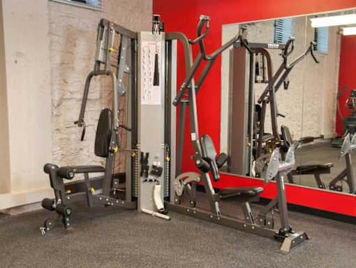 A gym with a variety of equipment including a leg press machine and a chest press machine.