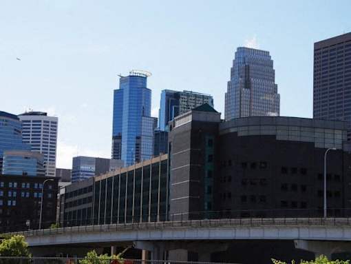 A cityscape with a bridge in the foreground and tall buildings in the background.