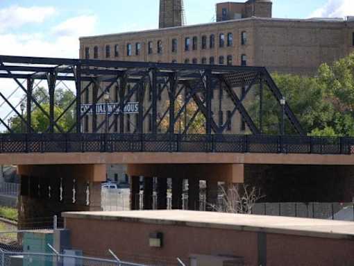 A bridge with a metal railing and a sign that says "HAL W. AOUS".