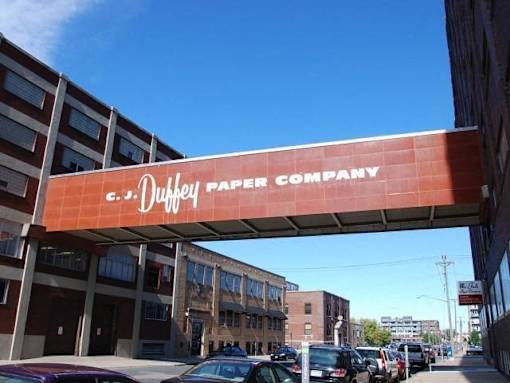 A street view of a Duffey Paper Company building with cars parked in front.