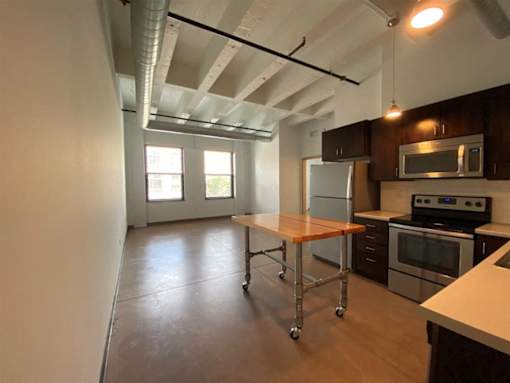 A kitchen with a table and a refrigerator.at Gurley Lofts, Minneapolis, 55401