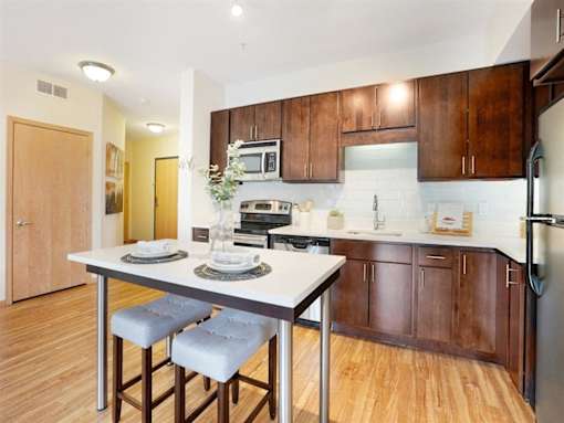 A kitchen with a table and chairs in front of it.at Third North Apartments, Minneapolis, MN 55401