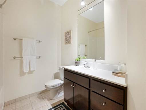 A bathroom with a toilet, sink, and a mirror.at Third North Apartments, Minneapolis