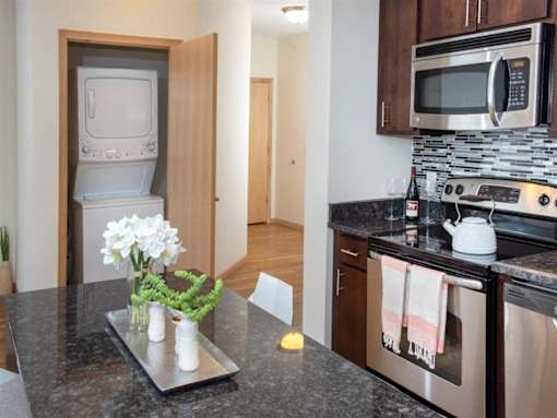 A kitchen with a granite countertop and stainless steel appliances.at Third North Apartments, Minneapolis