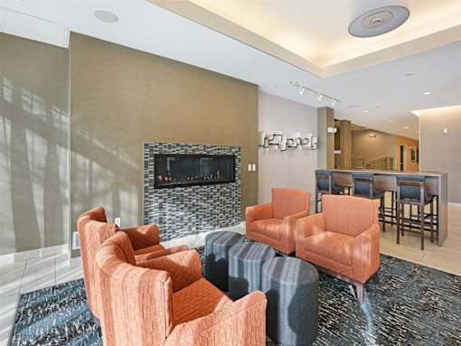 A living room with a fireplace and a row of orange chairs.at Third North Apartments, Minnesota, 55401