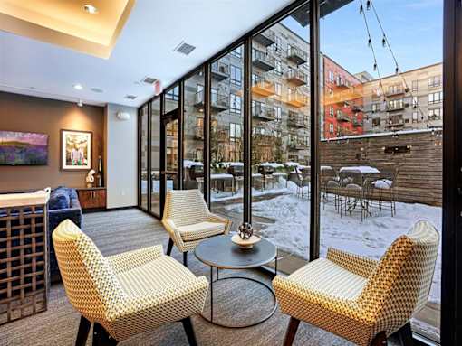 A room with a chair and a table in front of a window.at Third North Apartments, Minnesota