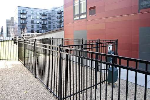 A black metal fence in front of a red building.at Third North Apartments, Minnesota