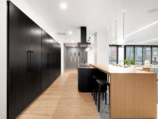 A modern kitchen with black cabinets and a wooden island.at Viridium Apartments, Minneapolis 